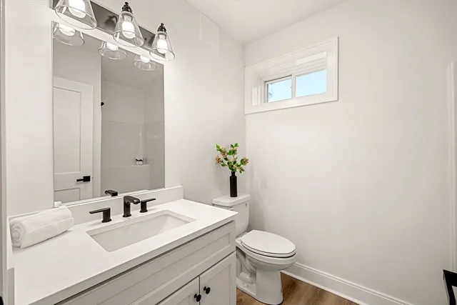 a bathroom with a sink vanity granite and toilet
