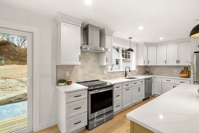 a kitchen with stainless steel appliances granite countertop a stove sink and cabinets