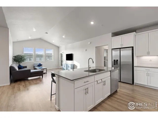 a kitchen with stainless steel appliances granite countertop a sink and a refrigerator