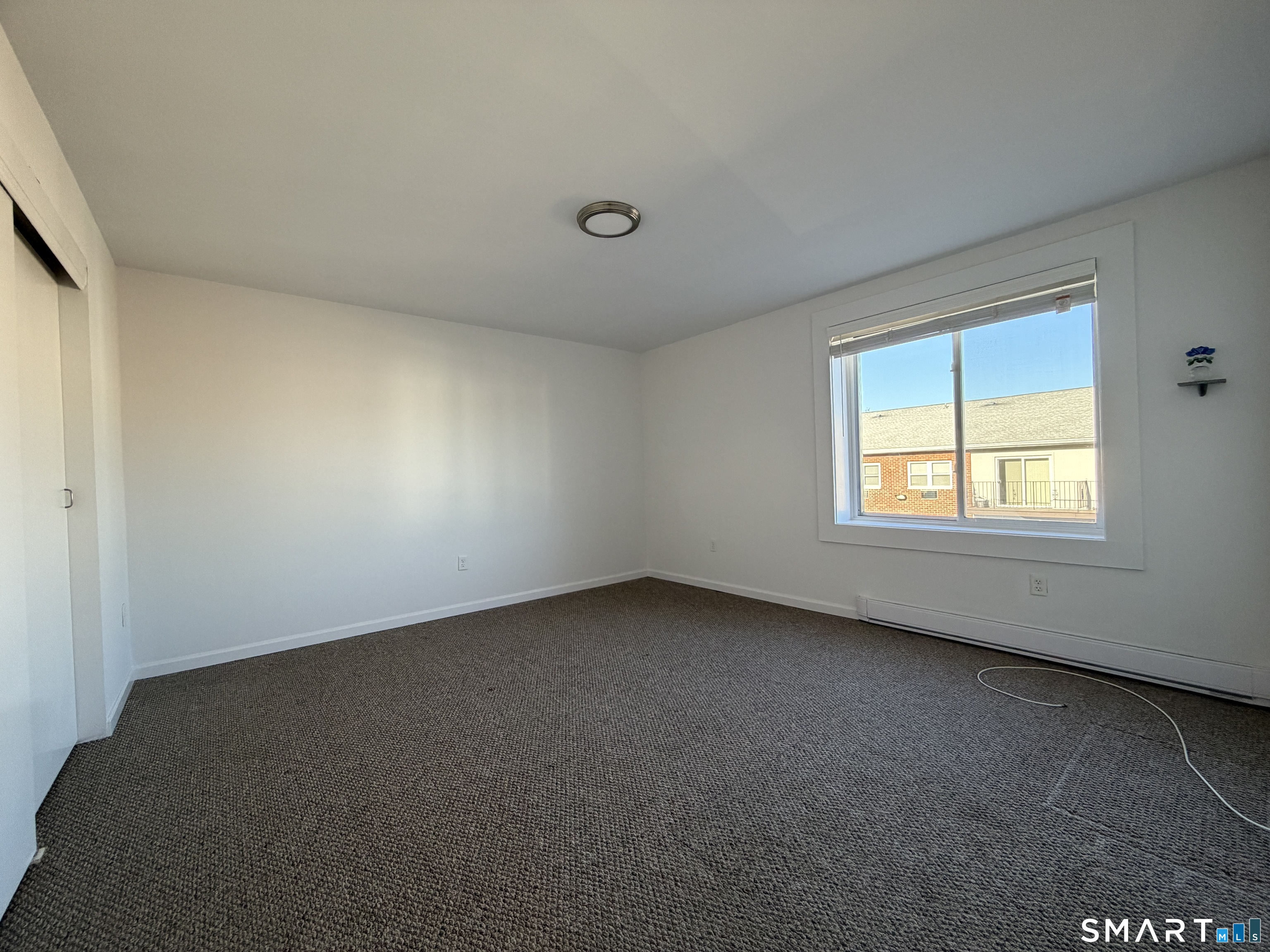 69 Cove Road, Unit B9 Stamford, CT 06902 - Photo 12 of 17 Expansive primary bedroom with natural light