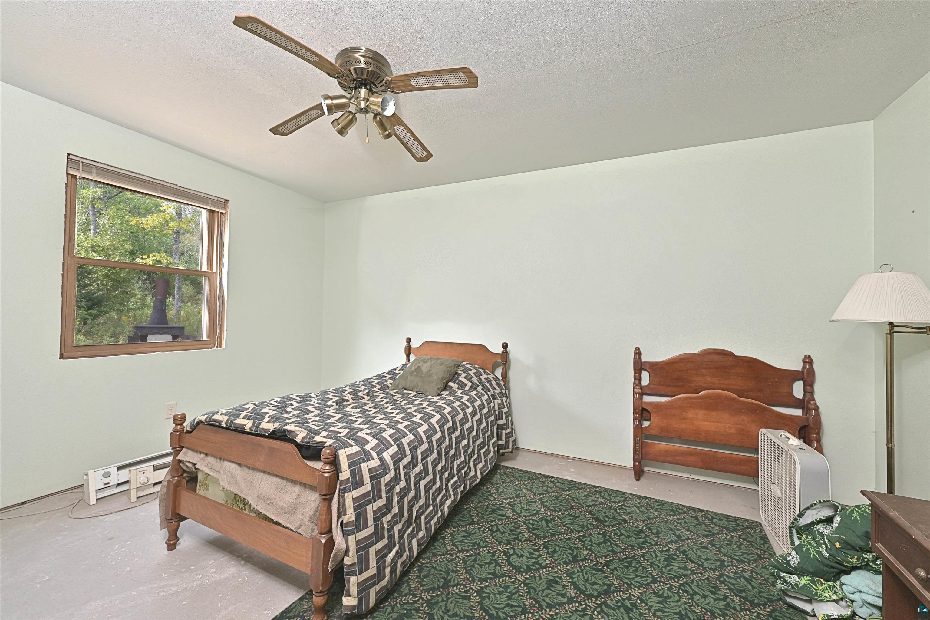 6555 Roses Road Finland, MN 55603 - Photo 11 of 24 Bright secondary bedroom with hardwood bed frames, ceiling fan with integrated lighting, carpet flooring, and natural light from window
