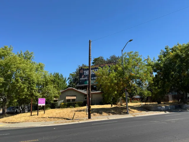 a street sign on a sidewalk next to a road