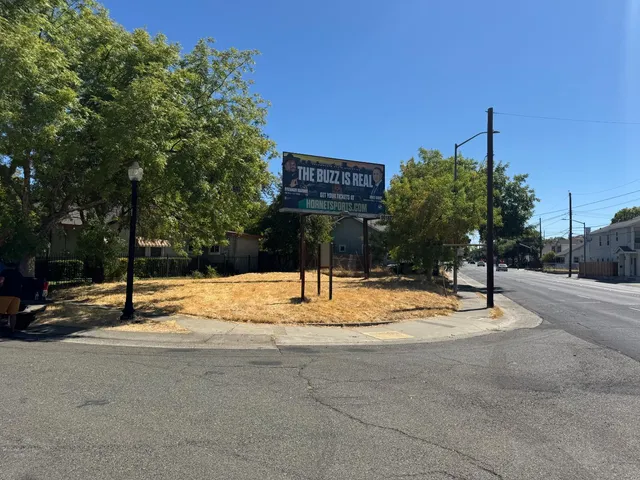 a street sign on a sidewalk next to a road