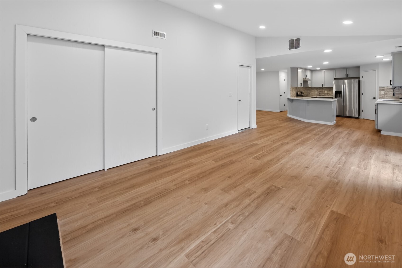 320 213th Place Southwest Bothell, WA 98021 - Photo 12 of 29 an empty room with wooden floor kitchen view and a window