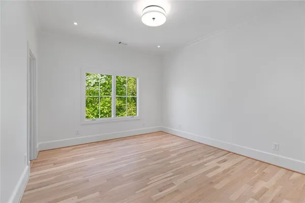 a view of an empty room with wooden floor