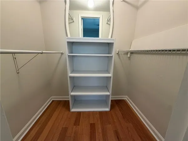 a view of walk in closet with empty racks