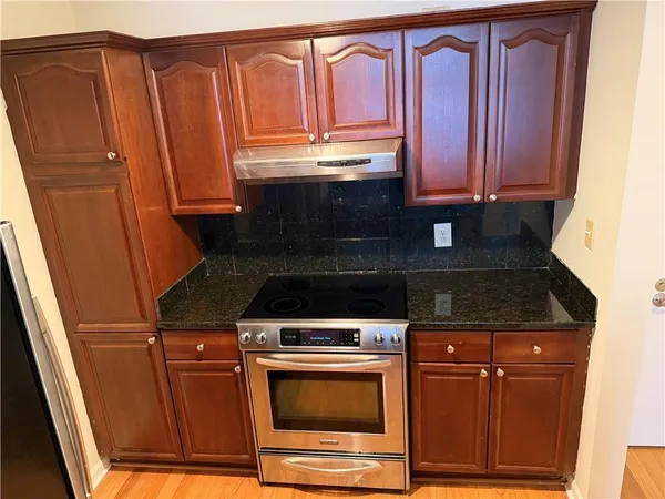 a view of a kitchen with wooden floor and cabinets