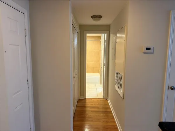 an empty room with wooden floor fireplace and windows