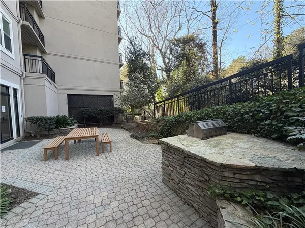 a view of a yard with plants and a table
