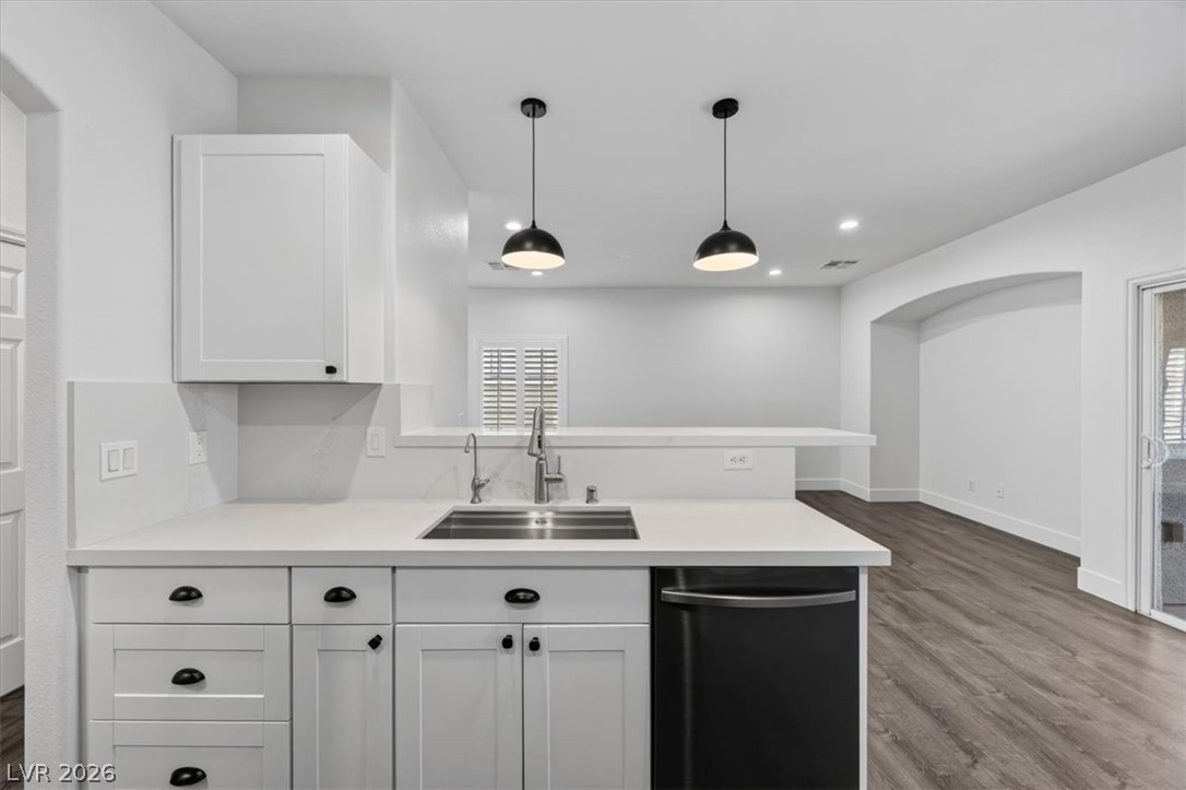 251 Integrity Ridge Drive Henderson, NV 89052 - Photo 4 of 32 Modern cabinetry and solid counters anchor this open-concept kitchen overlooking the adjacent living area.