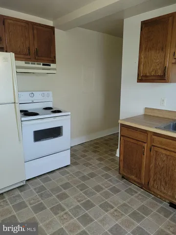 a kitchen with granite countertop a stove a sink and a microwave