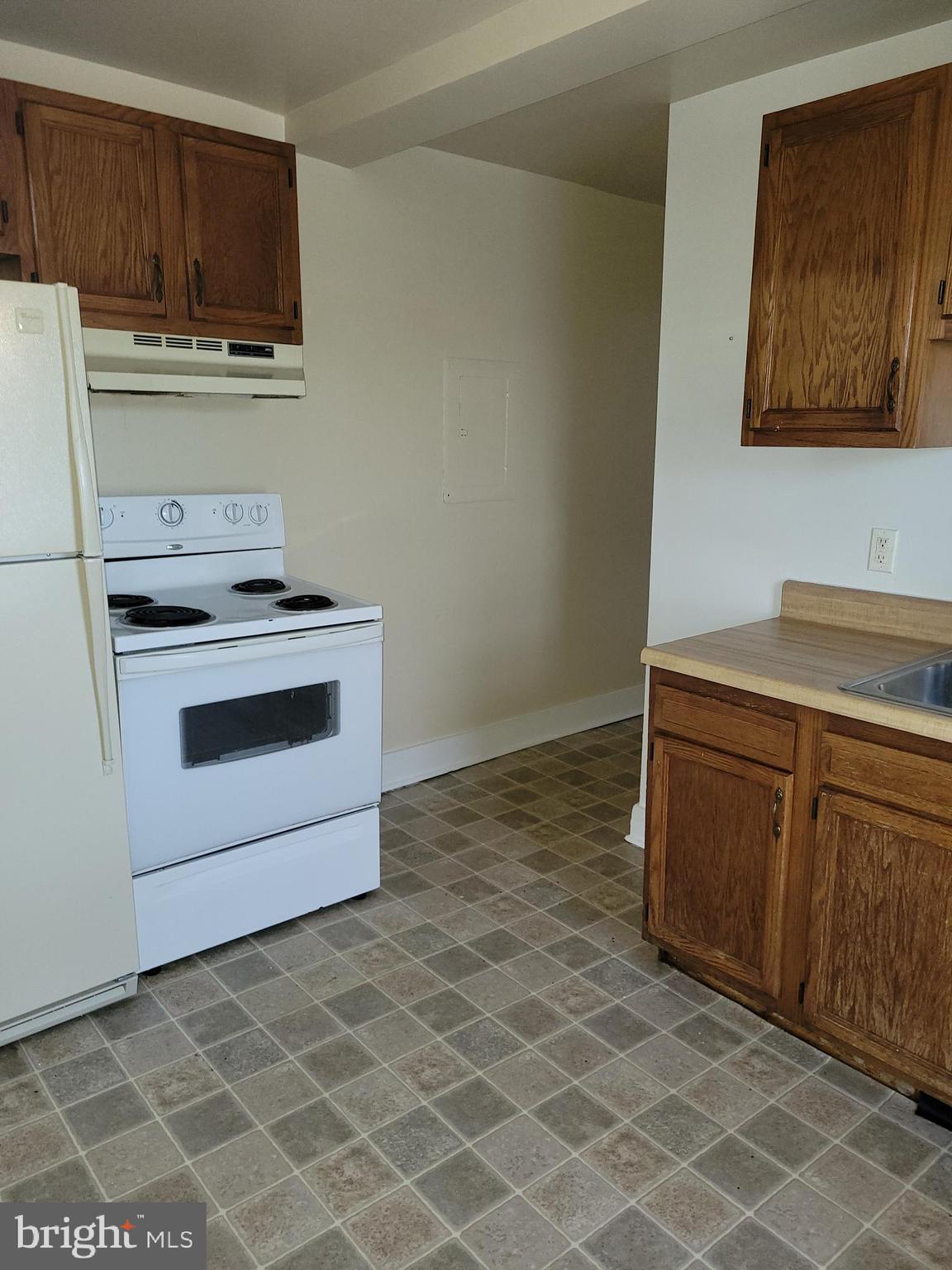 201 East Franklin Street, Unit 6 Hagerstown, MD 21740 - Photo 3 of 9 a kitchen with granite countertop a stove a sink and a microwave