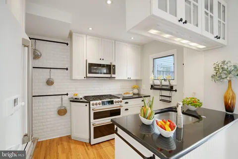 a kitchen with stainless steel appliances granite countertop a sink a stove and a refrigerator