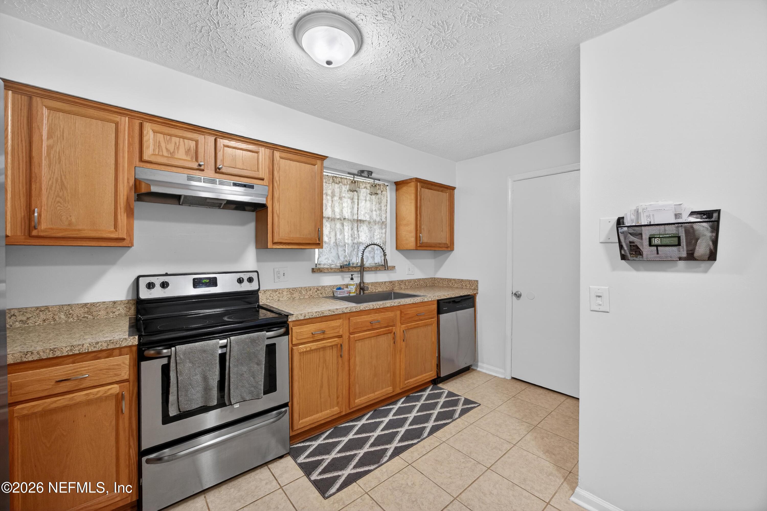 3570 Grassy Ride Drive Jacksonville, FL 32223 - Photo 17 of 51 a kitchen with stainless steel appliances a stove sink and cabinets