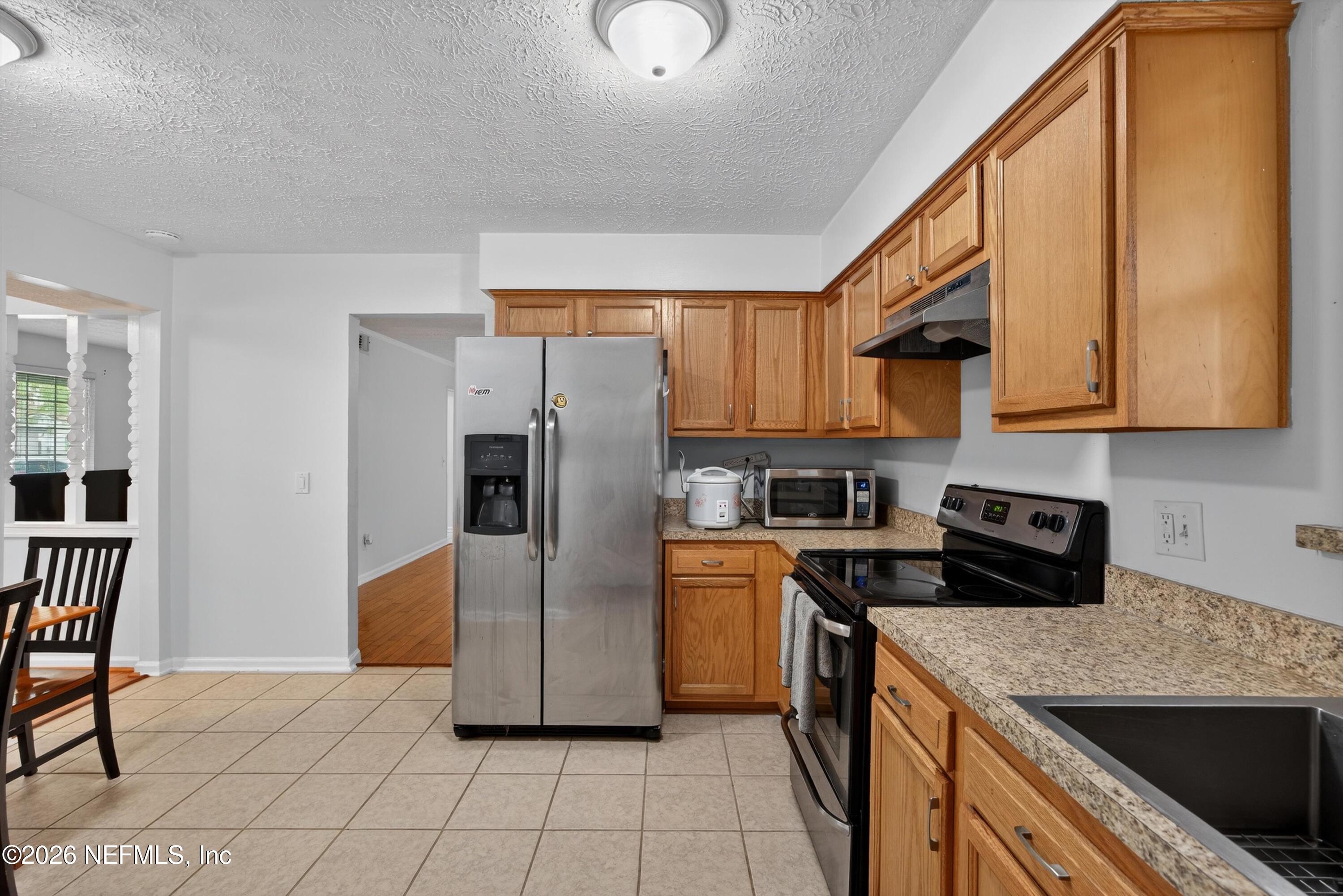 3570 Grassy Ride Drive Jacksonville, FL 32223 - Photo 19 of 51 a kitchen with a sink a refrigerator and cabinets