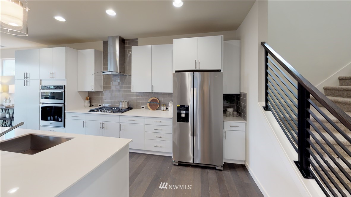 3129 193rd Place Southeast Bothell, WA 98012 - Photo 8 of 9 a kitchen with white cabinets and refrigerator