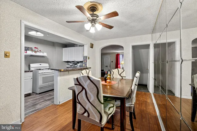 a kitchen with stainless steel appliances kitchen island granite countertop a dining table chairs and a refrigerator