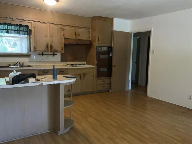 a kitchen with wooden cabinets a sink a window and stainless steel appliances