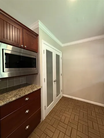 a view of an empty room with wooden floor and a cabinet
