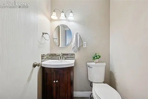 a bathroom with a toilet a sink and mirror