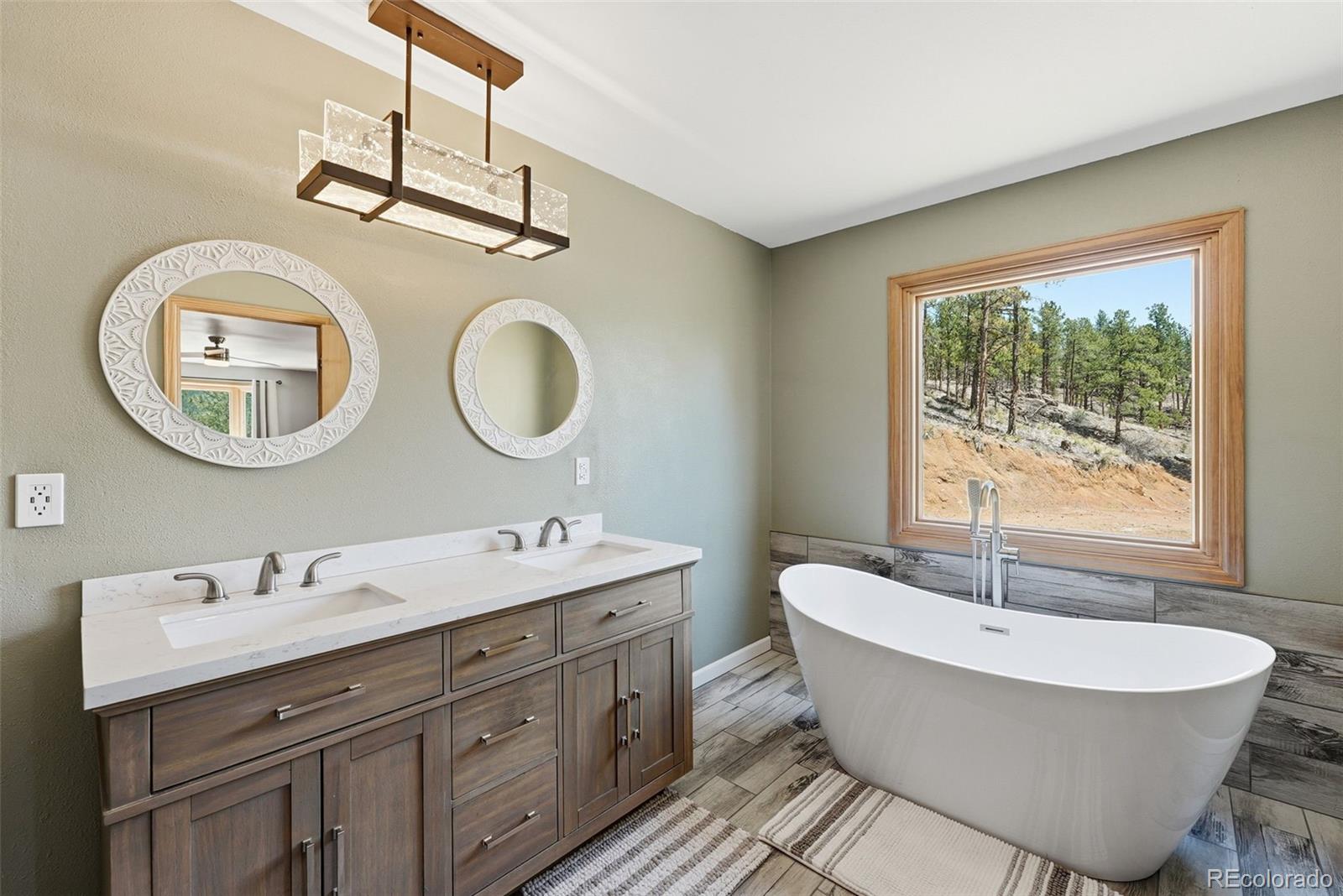 16687 Ouray Road West Pine, CO 80470 - Photo 22 of 49 a spacious bathroom with a double vanity sink a mirror and a bathtub