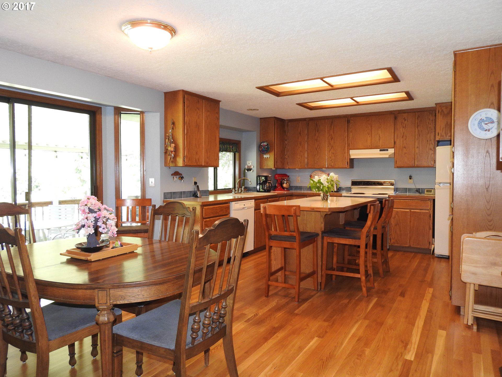 19637 Southeast Heuke Road Damascus, OR 97089 - Photo 4 of 14 a dining hall with stainless steel appliances kitchen island a table and chairs in it
