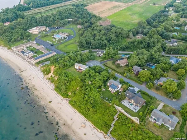 an aerial view of a houses with a yard and lake view