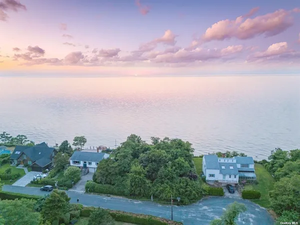 an aerial view of a house with a yard and lake view