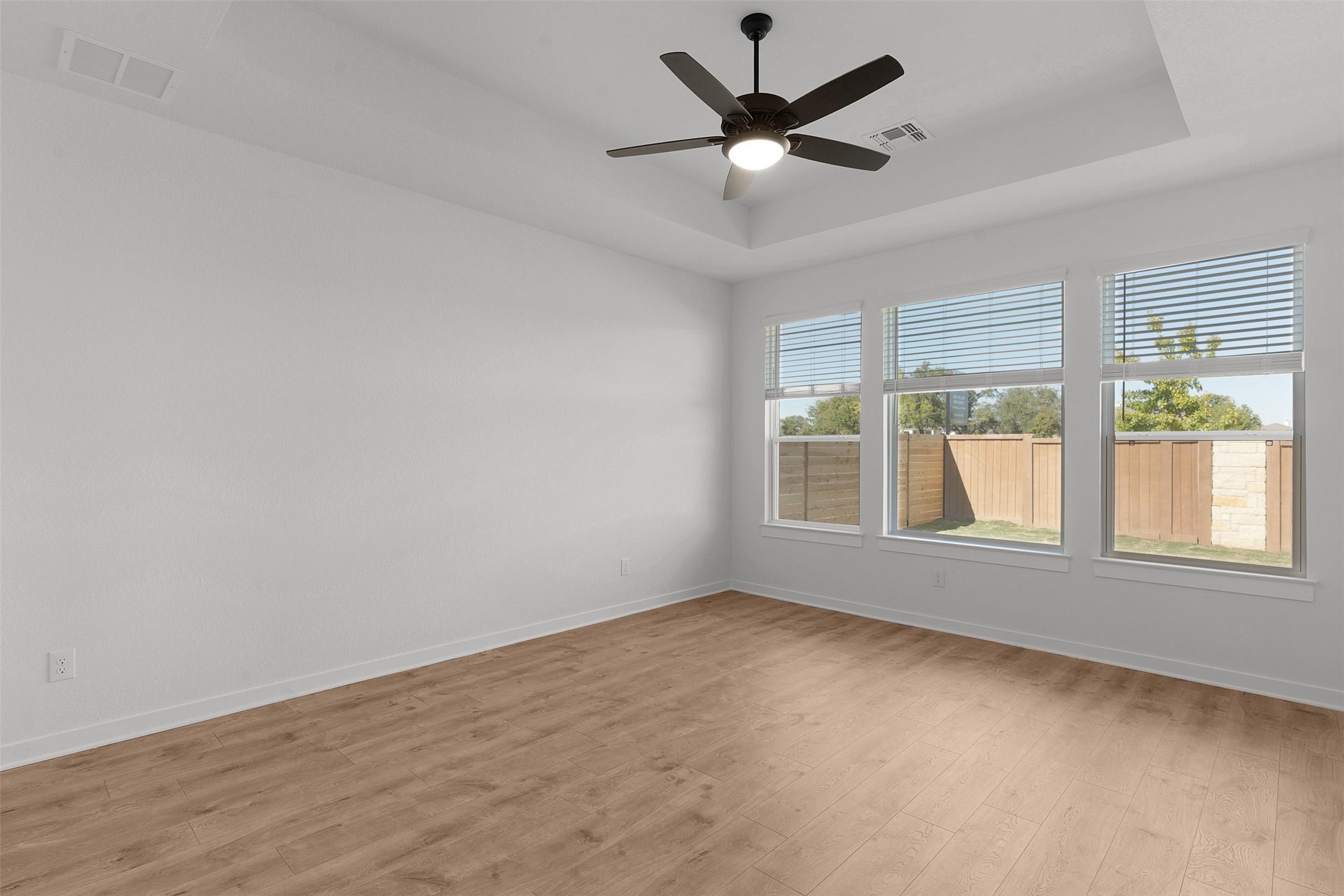328 Ridgewell Loop Georgetown, TX 78633 - Photo 17 of 28 Spare room with a tray ceiling, light wood-type flooring, and ceiling fan