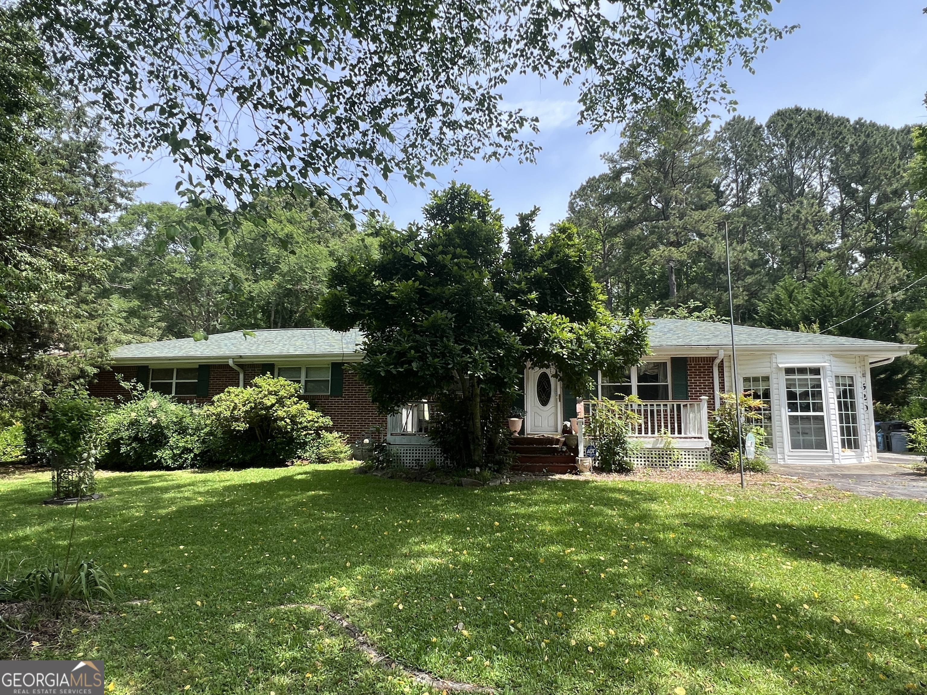 a front view of a house with a yard and trees