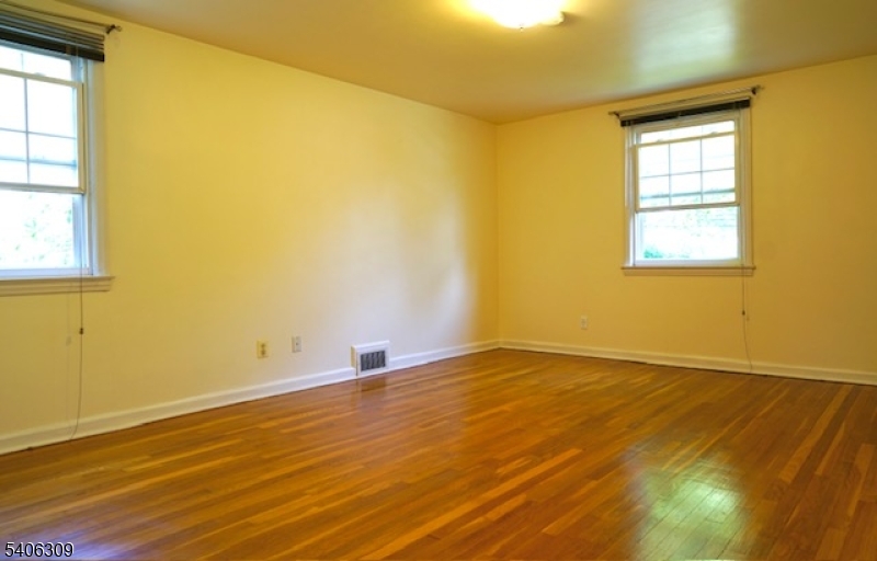 17 Wellington Road Livingston, NJ 07039 - Photo 11 of 20 a view of an empty room with wooden floor and a window
