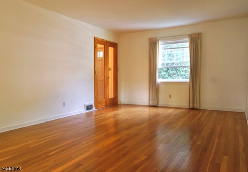 17 Wellington Road Livingston, NJ 07039 - Photo 9 of 20 an empty room with wooden floor and windows
