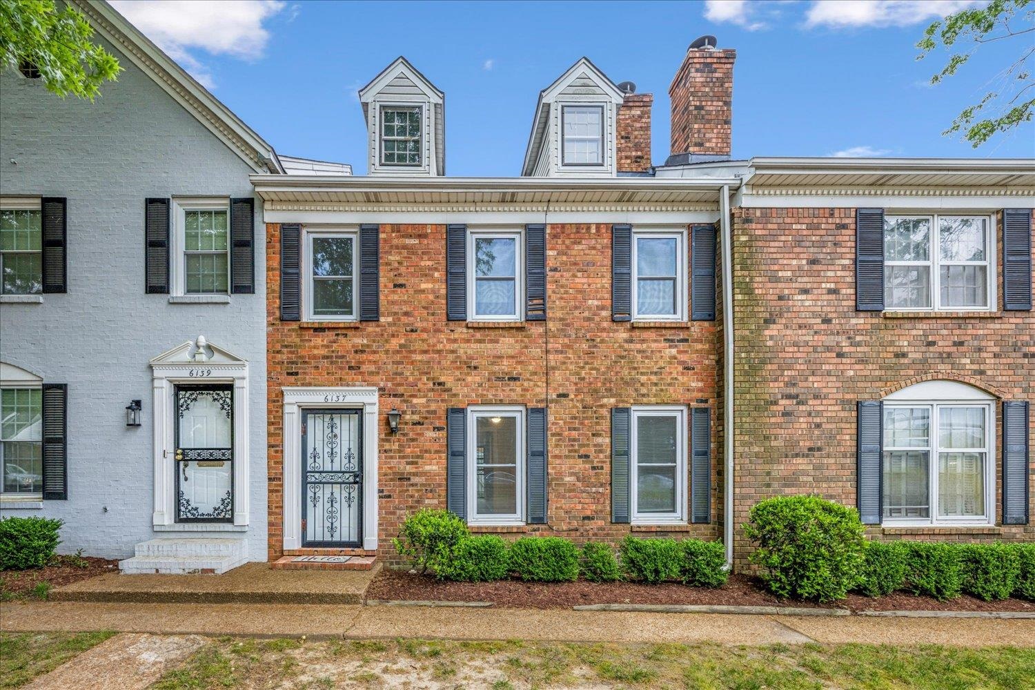 Colonial inspired home featuring brick siding and a chimney