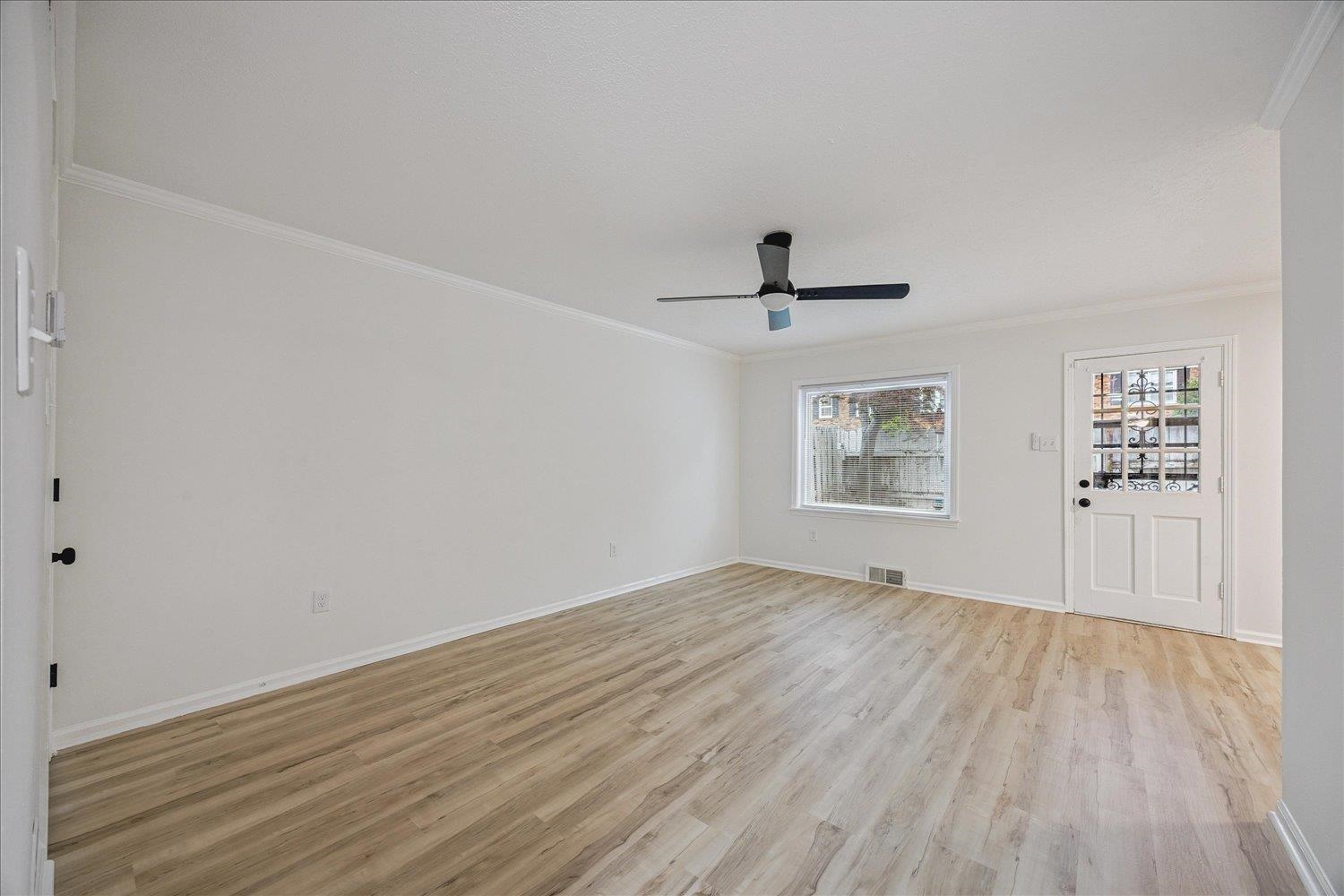 6137 Quince Road Memphis, TN 38119 - Photo 11 of 19 Unfurnished living room with light wood finished floors, ornamental molding, and a ceiling fan