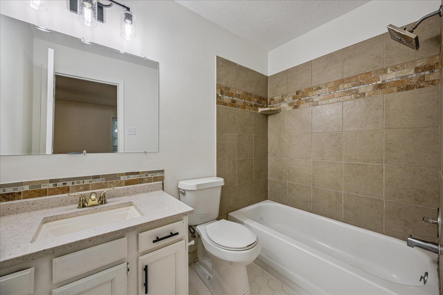 6137 Quince Road Memphis, TN 38119 - Photo 16 of 19 Full bath with vanity, bathing tub / shower combination, and a textured ceiling