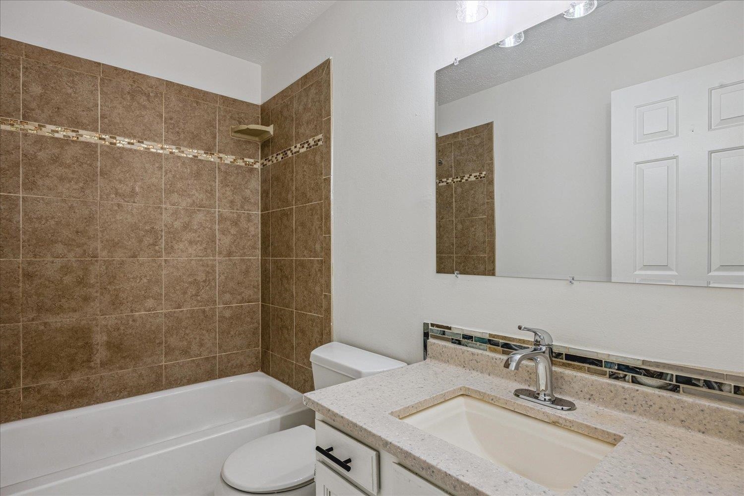 6137 Quince Road Memphis, TN 38119 - Photo 19 of 19 Bathroom featuring vanity, a textured ceiling, and shower combination