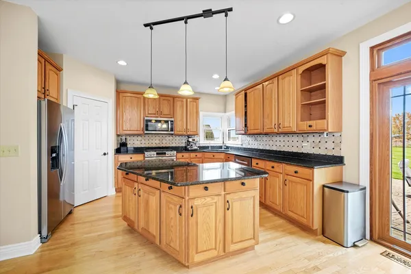 a kitchen with stainless steel appliances granite countertop a sink a stove and a refrigerator