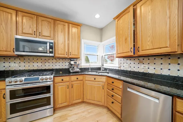 a kitchen with granite countertop cabinets stainless steel appliances and a window