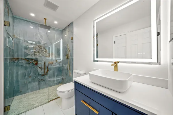 a bathroom with a sink a toilet and shower