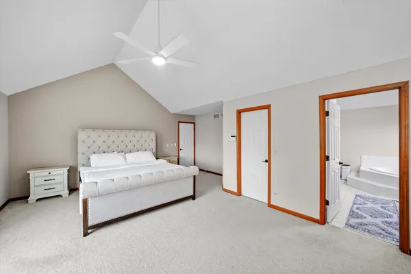 a spacious bedroom with a bed and a lamp