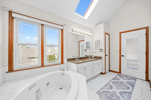a large spacious bathroom with a granite countertop tub sink and mirror