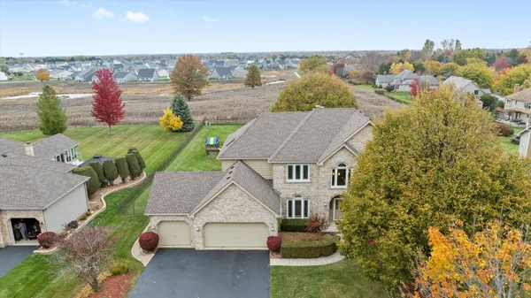 an aerial view of a house with a garden and lake view