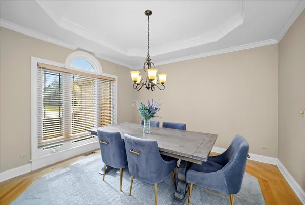 a dining room with furniture a chandelier and wooden floor