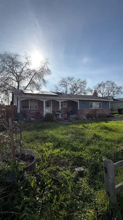 a view of a house with a yard and potted plants