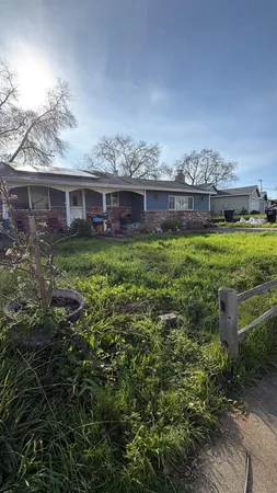 a view of a house with a yard and potted plants