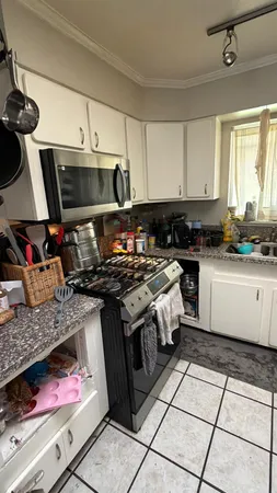 a kitchen with stainless steel appliances granite countertop a stove a sink and a microwave