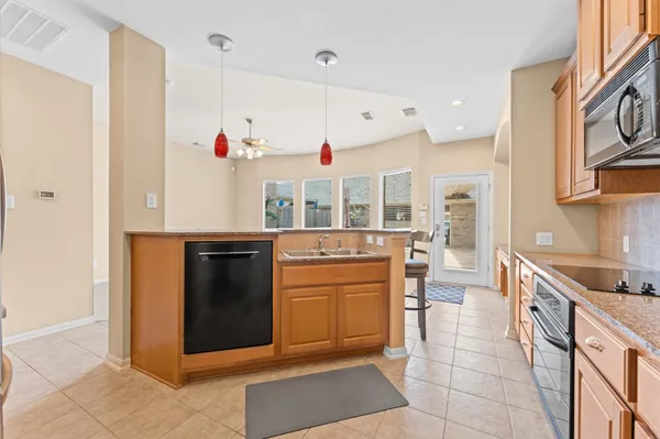a kitchen with stainless steel appliances granite countertop a stove a sink and a refrigerator