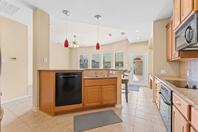 a kitchen with stainless steel appliances granite countertop a stove a sink and a refrigerator