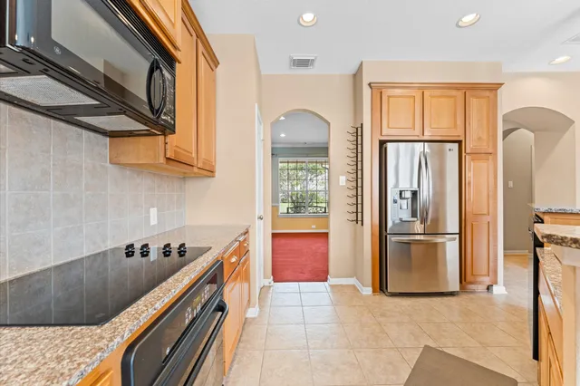 a kitchen with stainless steel appliances granite countertop a refrigerator a stove and a sink with cabinets