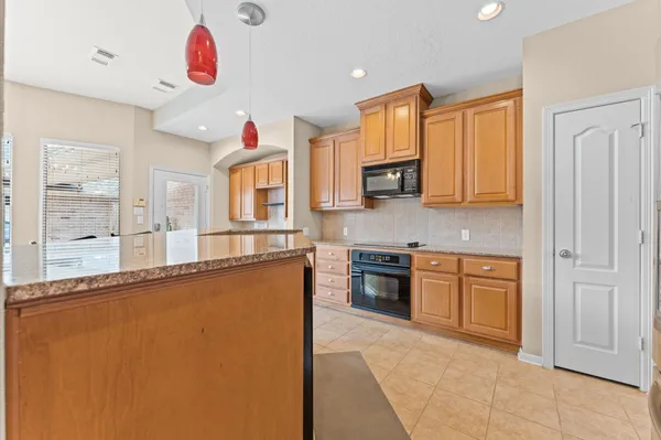 a kitchen with stainless steel appliances granite countertop a stove a sink and a refrigerator